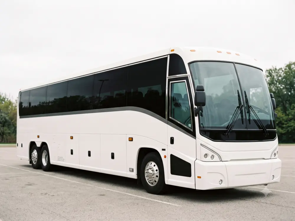 Premium coach bus with tinted windows parked against a plain outdoor backdrop